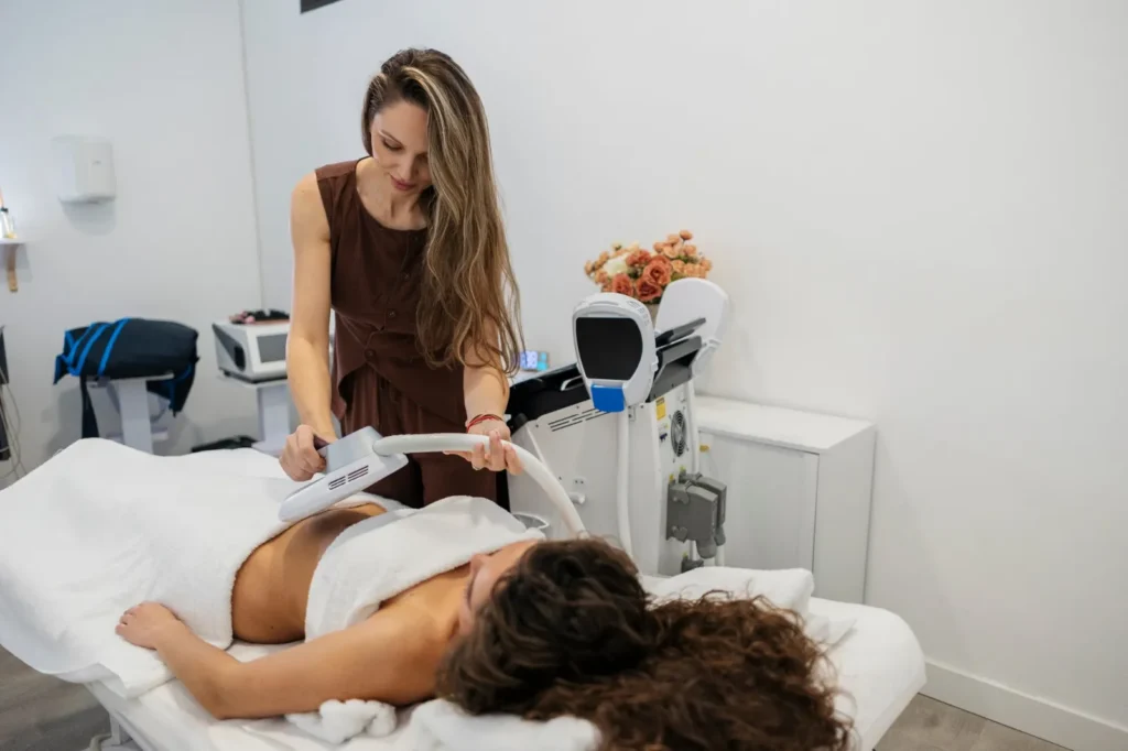 Séance Esthe-SHAPE : applicateur positionné sur l’abdomen d’une cliente allongée